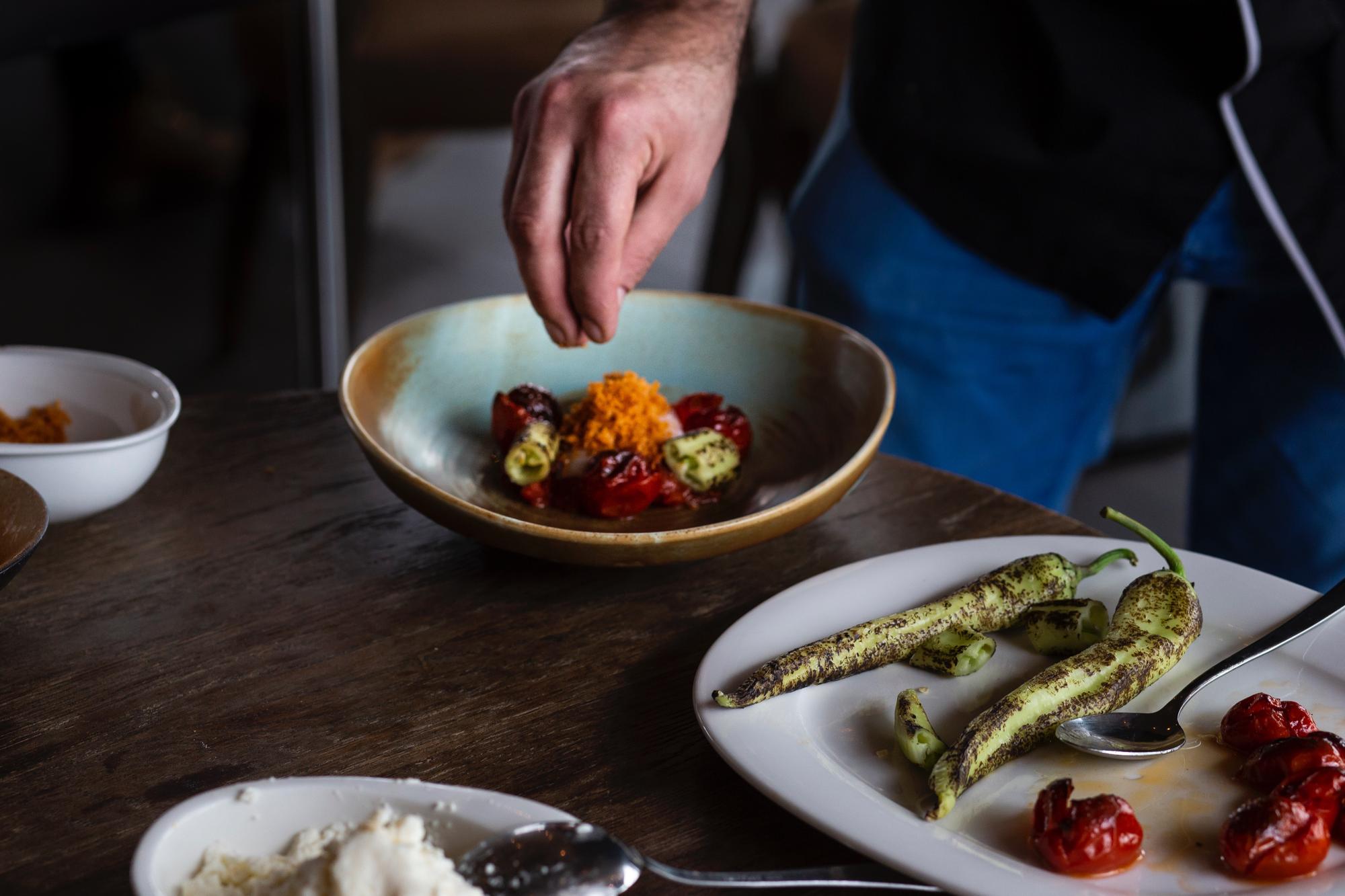 chef arranging a plated dish on a wooden table